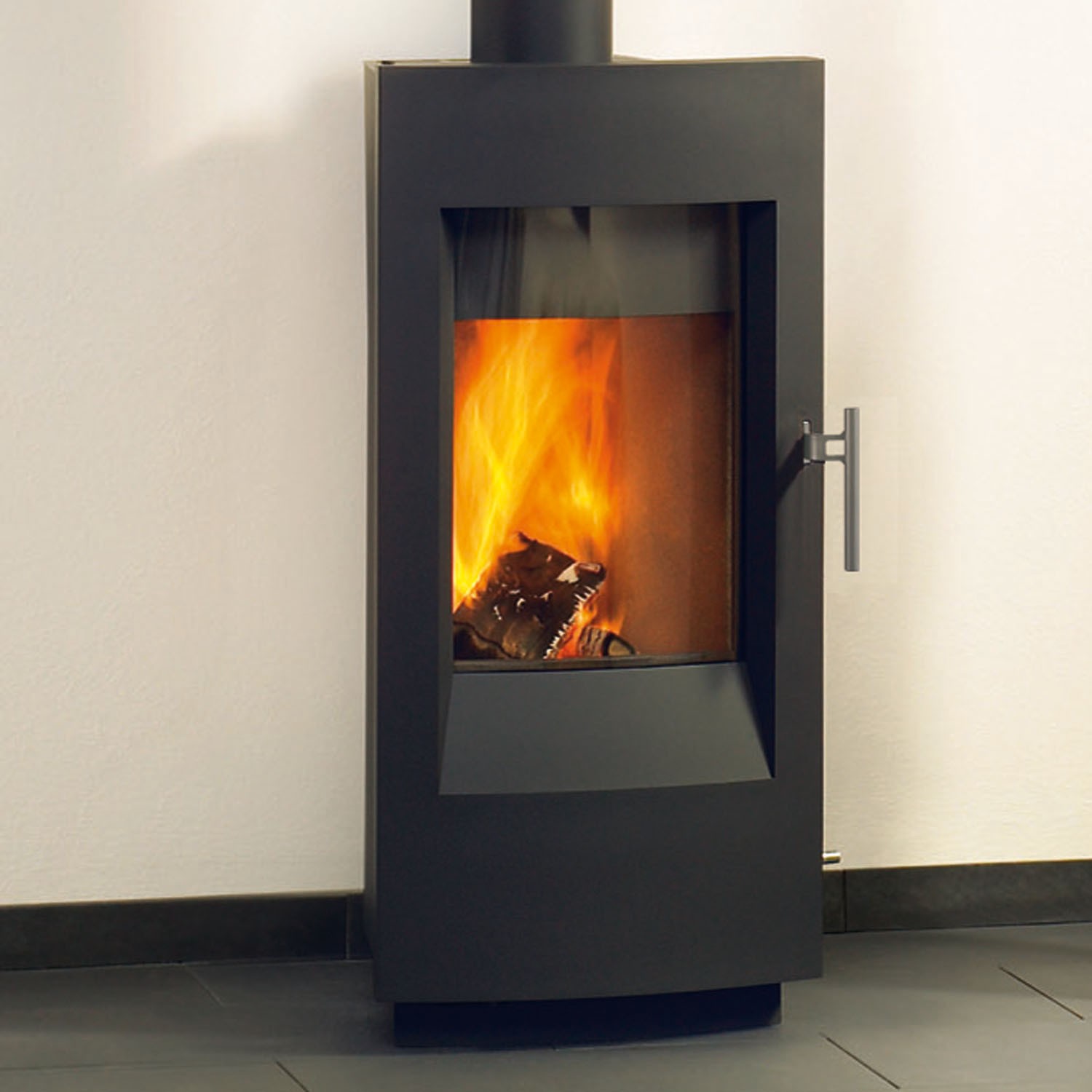 Tula 8190 Wood Stove black modern glass front with handle on tile floor and white wall in the background.
