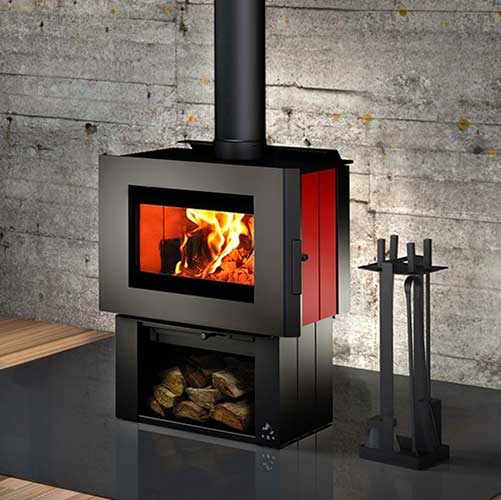 Osburn Soho Wood Stove modern look with wood underneath and tools to the right.  Concrete wall in the background.