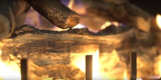 flickering fire between wood logs in a fireplace