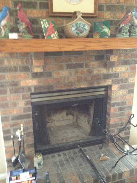 Older brick fireplace and hearth with christmas decortations on it 