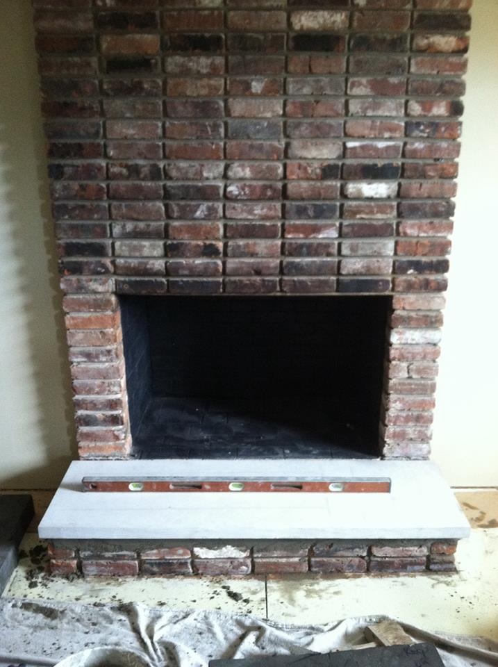 Fireplace and hearth with dark brown and balck bricks with dropcloth in front