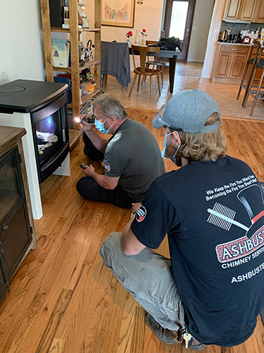 Techs inspecting a fireplace - Ashbusters chimney