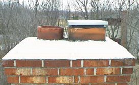 chimney with snow covering it and one circular one rectangular vent with metal damper on it