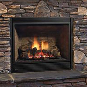 black fireplace with fire burning it and different shape bricks on the hearth wall behind it
