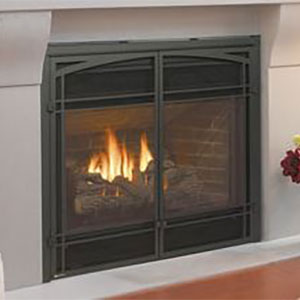large black fireplace insert with arched doors and white hearth fire is burning inside it