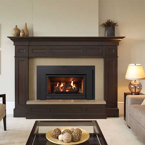 large dark brown hearth with vases on it black gas fireplace insert couch and coffee table in living room