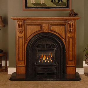 large wooden hearth with painting above it arch shaped black fireplace insert in it