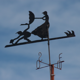 a weather vane with Mary Poppins, her umbrella, and a chimney sweep