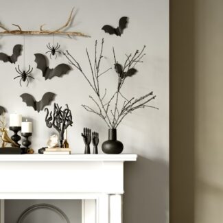 bat, spider, and other halloween decor on a white mantel