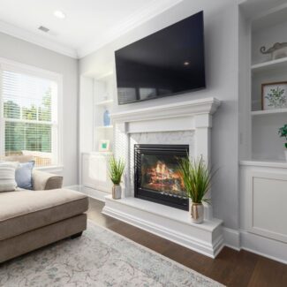 a fireplace with a white surround and mantel in a nicely decorated living room